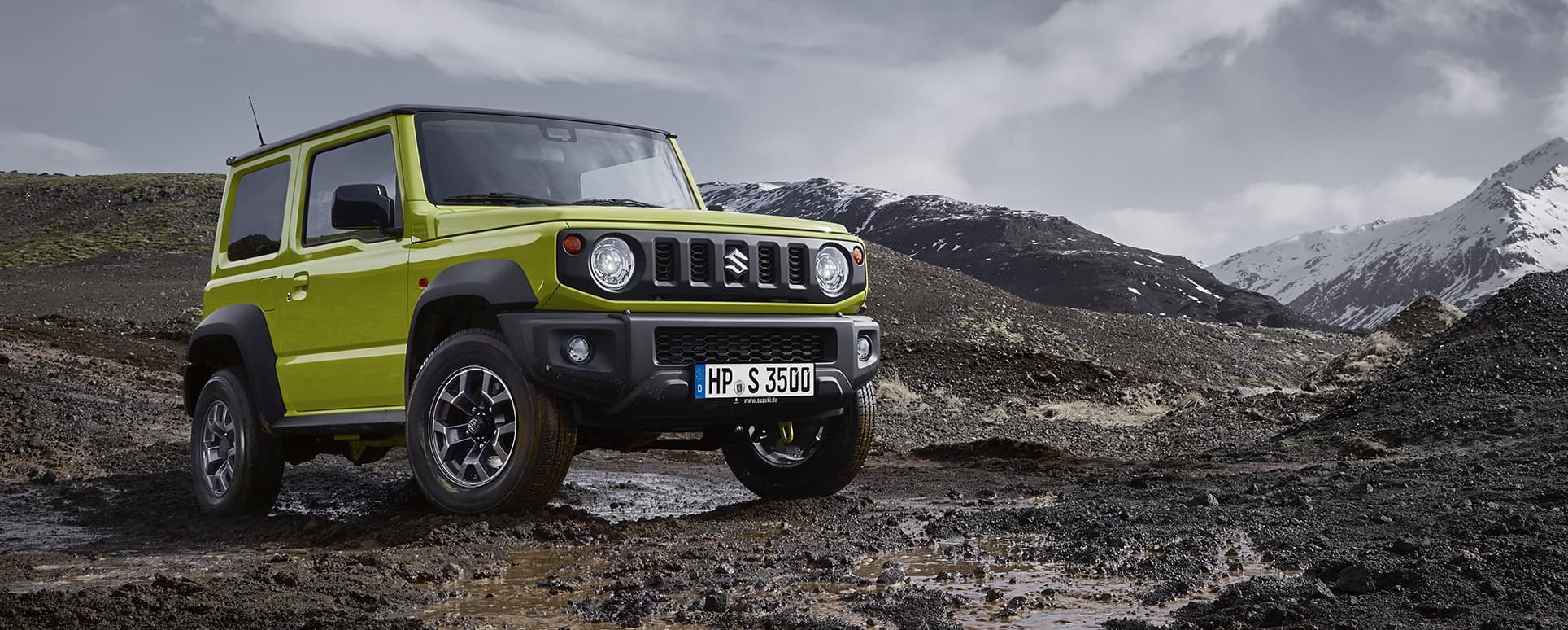 Abblidung zeigt einen grünen Jimny, der auf steinigem Untergrund auf einem Berg fährt