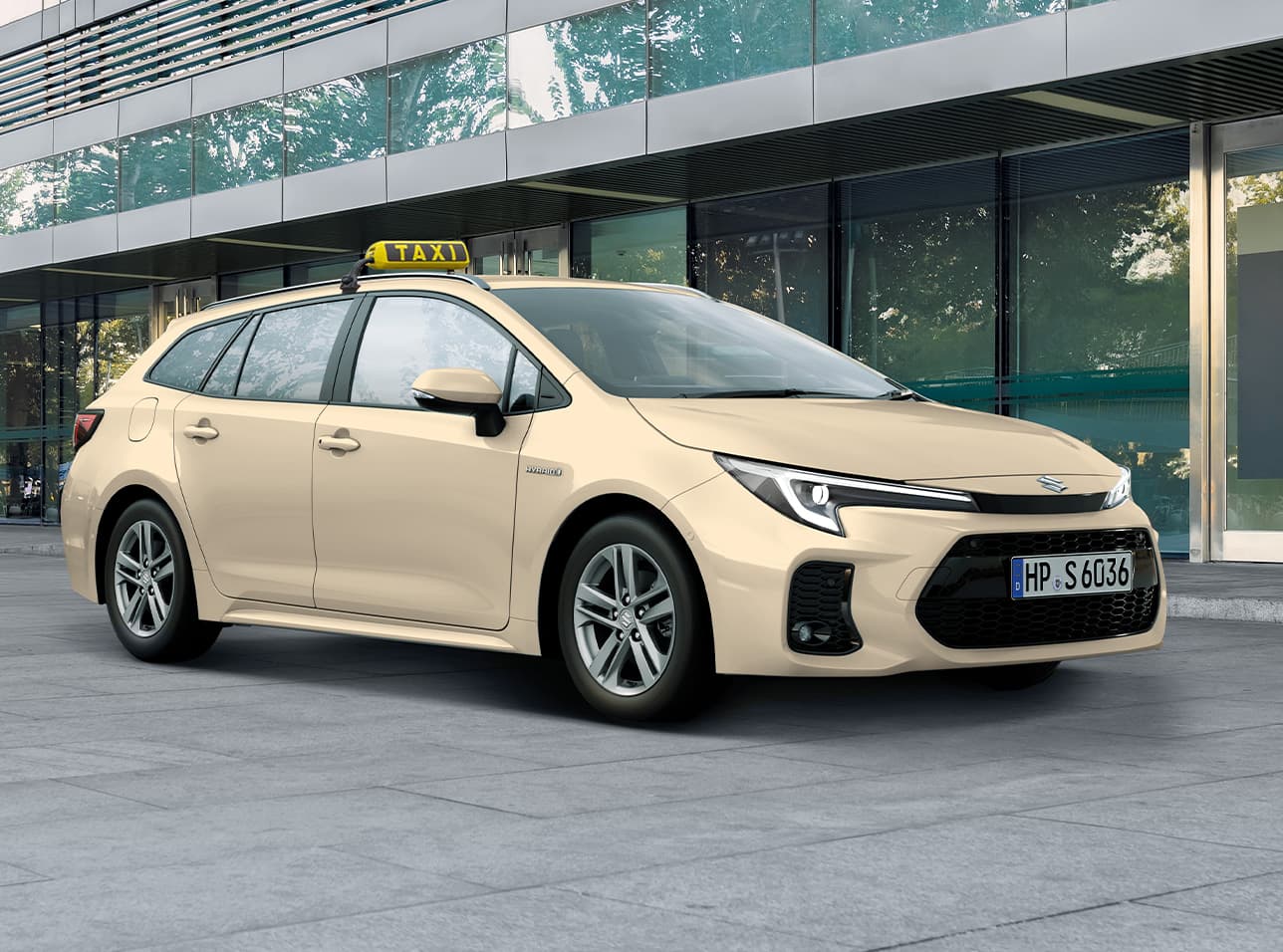 Ein Suzuki Swace in typischer Taxi-Optik mit hellgelber Lackierung und mit Taxi-Schild wartet vor einem Gebäude