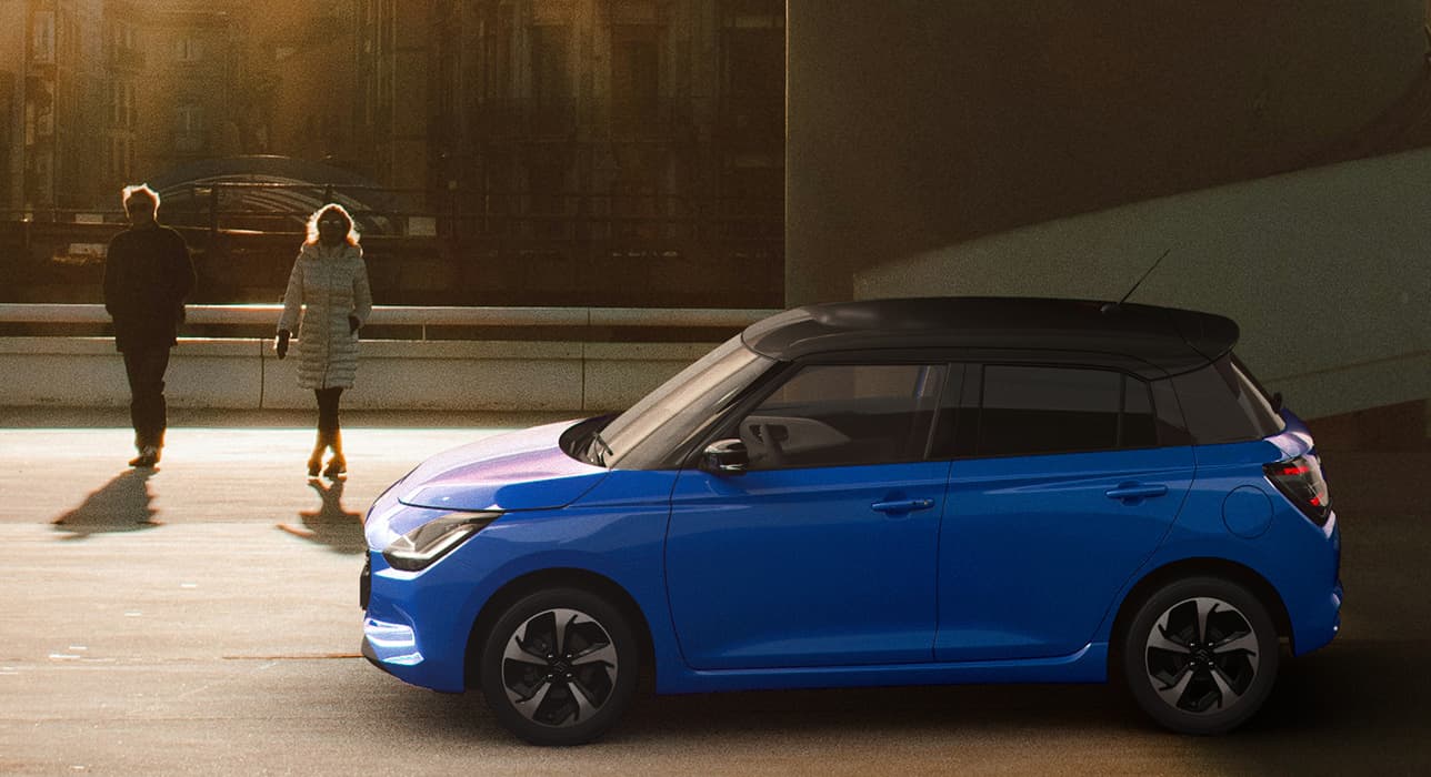 Abbildung zeigt blauen Swift mit UV & IR absorbierende Scheiben, der an einer Straße parkt und zwei Personen daneben spazieren gehen