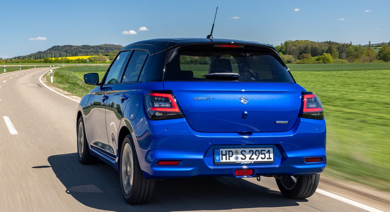 Abbildung zeigt Heckdesign eines blauen Swifts fahrend auf einer Straße