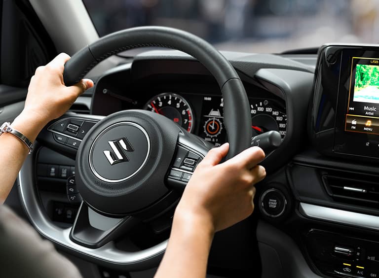 Abbildung zeigt Hände an einem Lenkrad